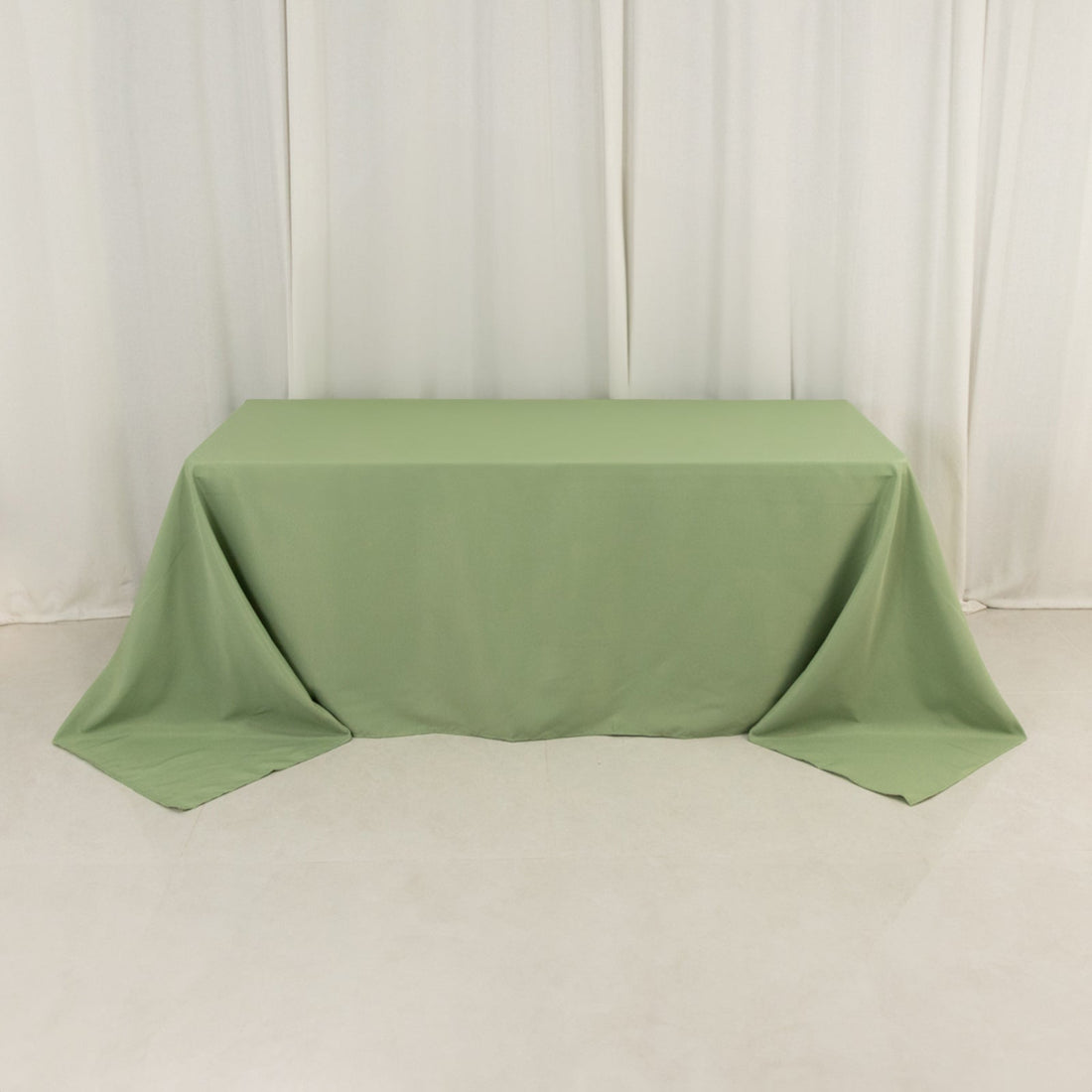 Green tablecloth draped over a table on a plain background.