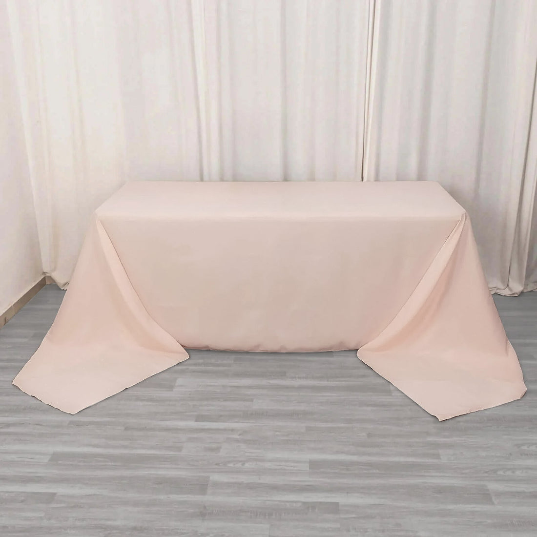 Pink tablecloth draped elegantly over a table in a studio setting.