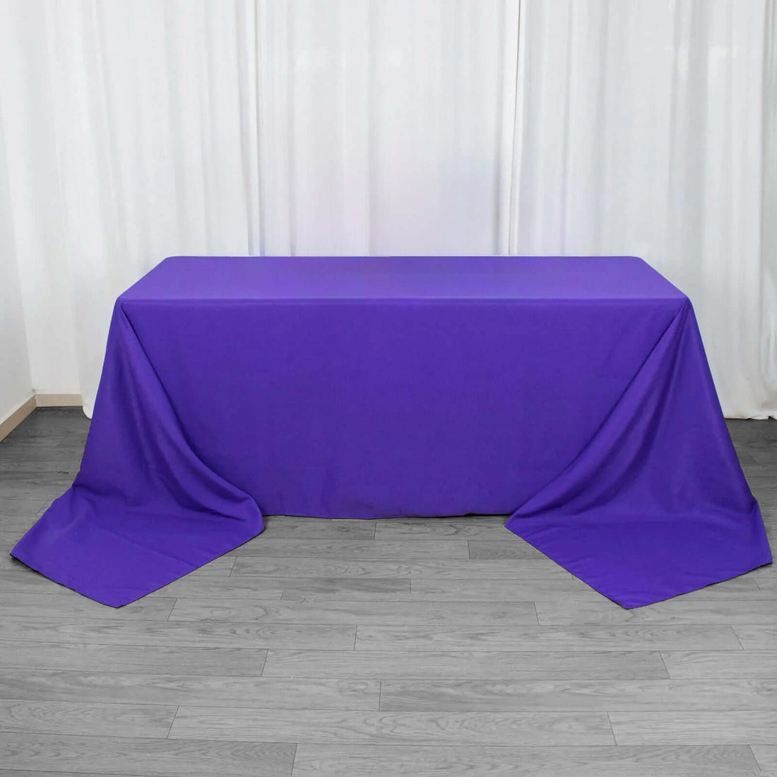 Purple tablecloth draped over a table in a studio setting.