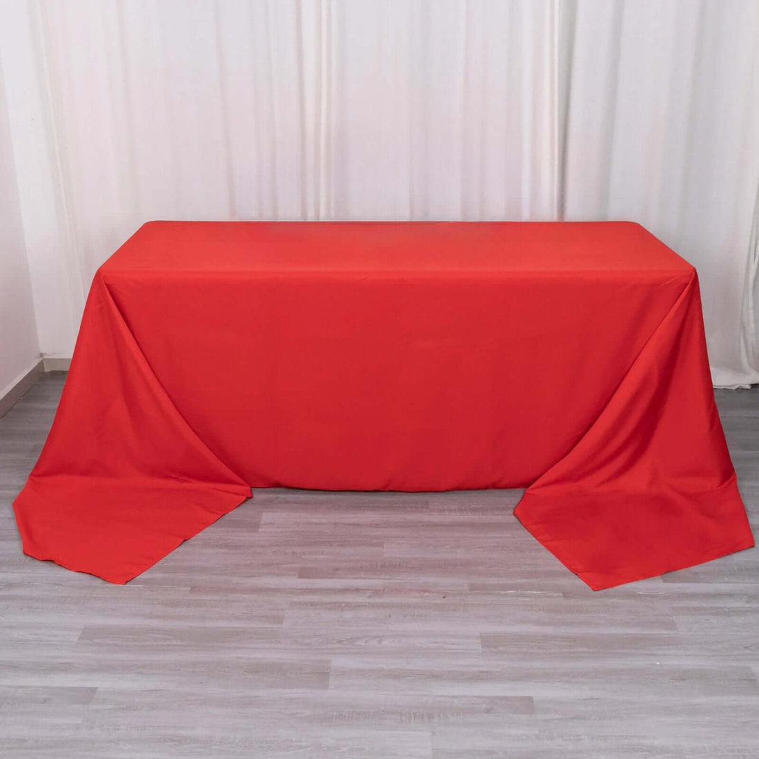 Red tablecloth draped over a table in a minimalistic setting.