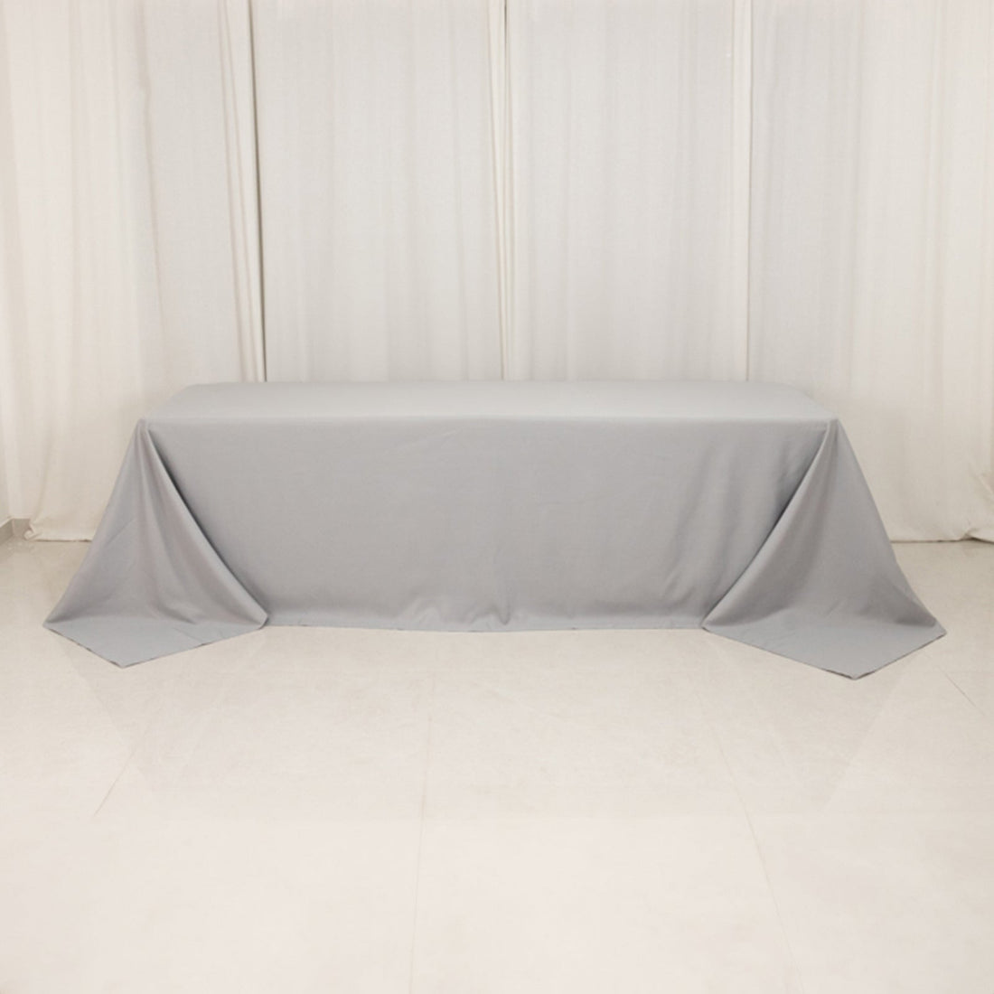 Gray tablecloth draped over a table in a studio setting.