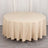Round beige tablecloth draped over a circular table.