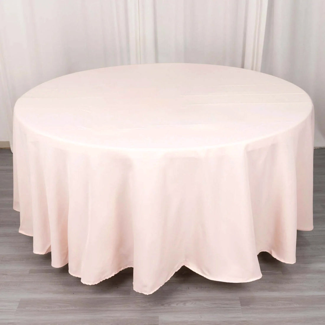 Round pink tablecloth draped elegantly over a table.