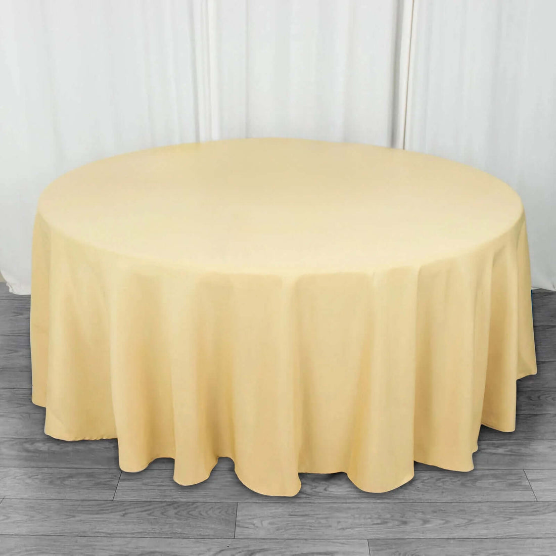 Round yellow tablecloth draping over a circular table