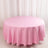 Round pink tablecloth on a plain backdrop.