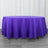 Purple round tablecloth draped over a table in a staged setting.