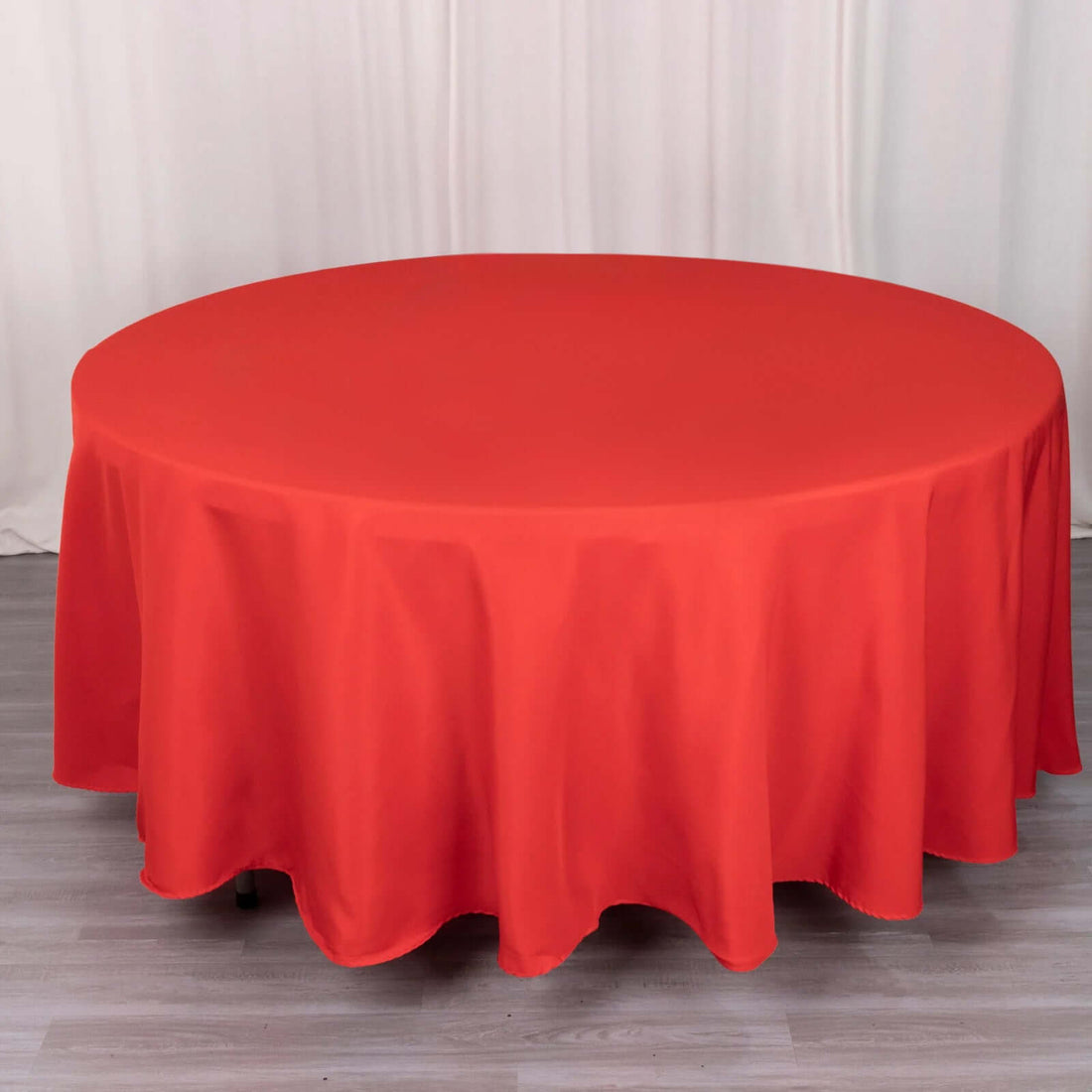 Round red tablecloth on a wooden table.