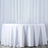 White tablecloth draped over a round table in a studio setting.