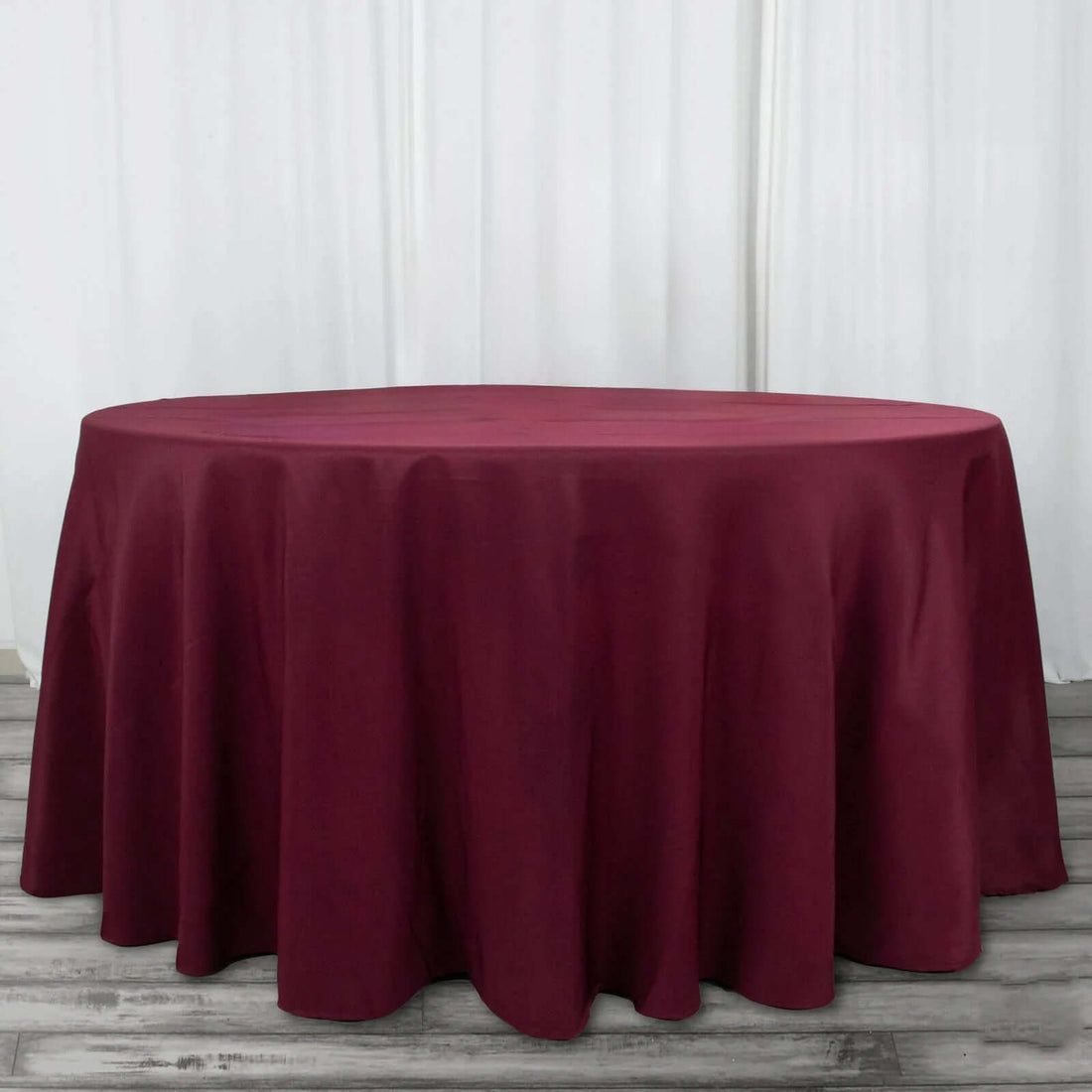 Burgundy round tablecloth on a plain background