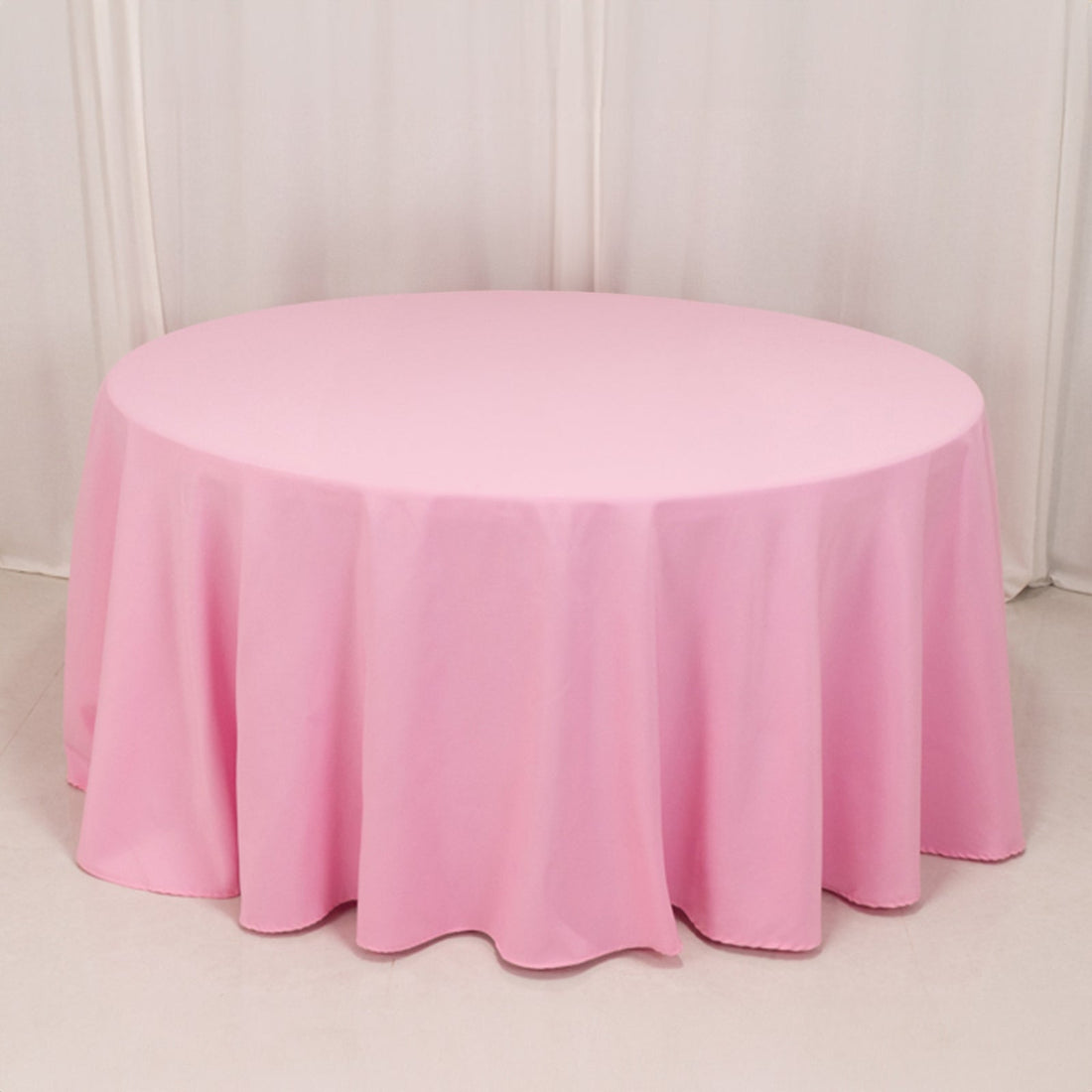 Round pink tablecloth draping elegantly over a table surface.