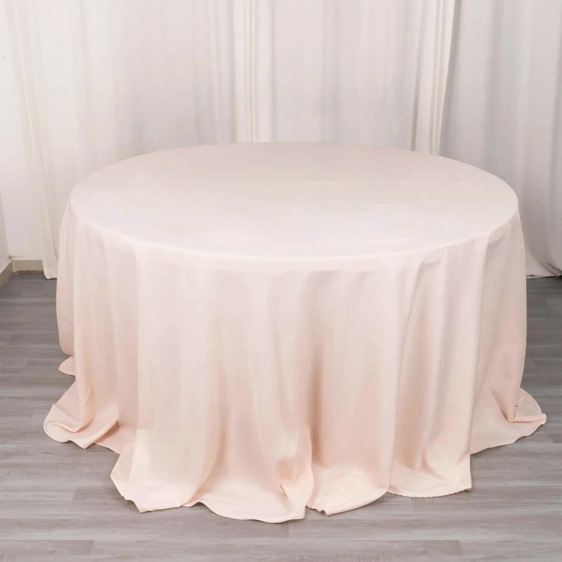 Round blush tablecloth elegantly draped on a table.