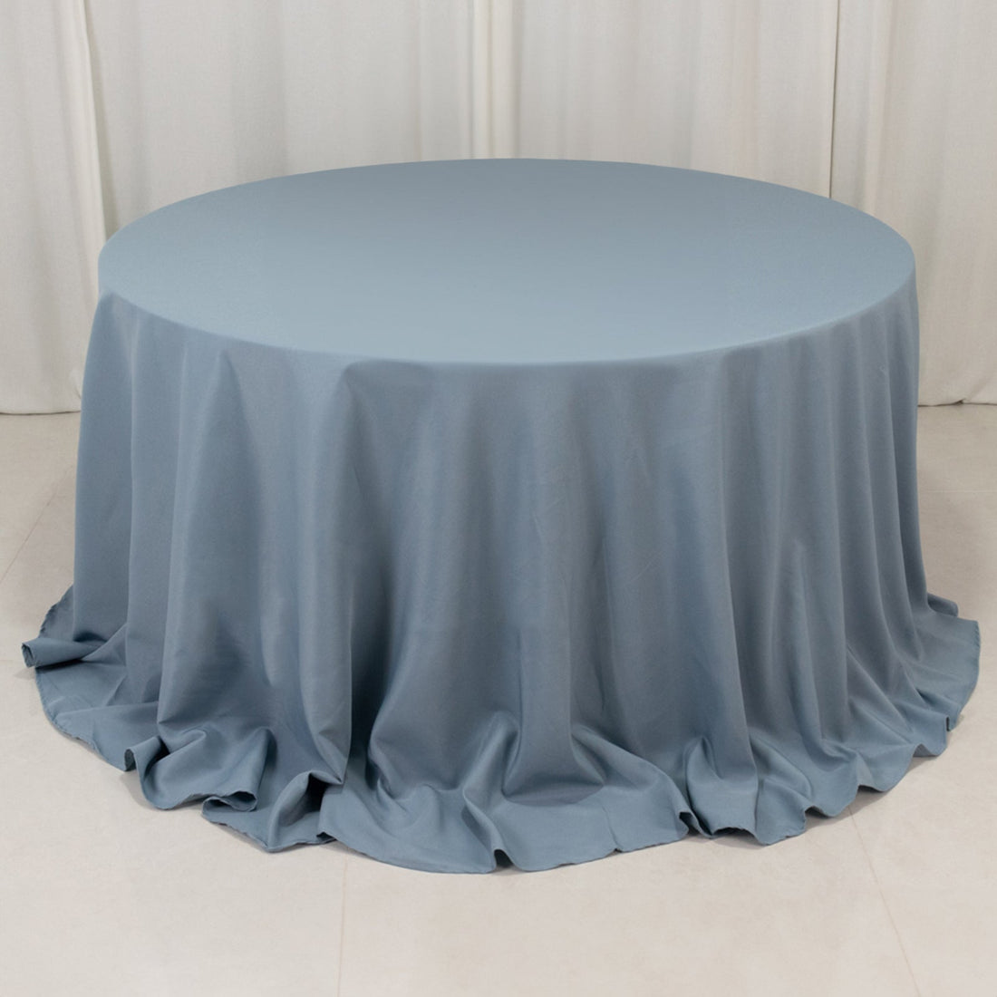Round blue tablecloth with draped fabric texture.