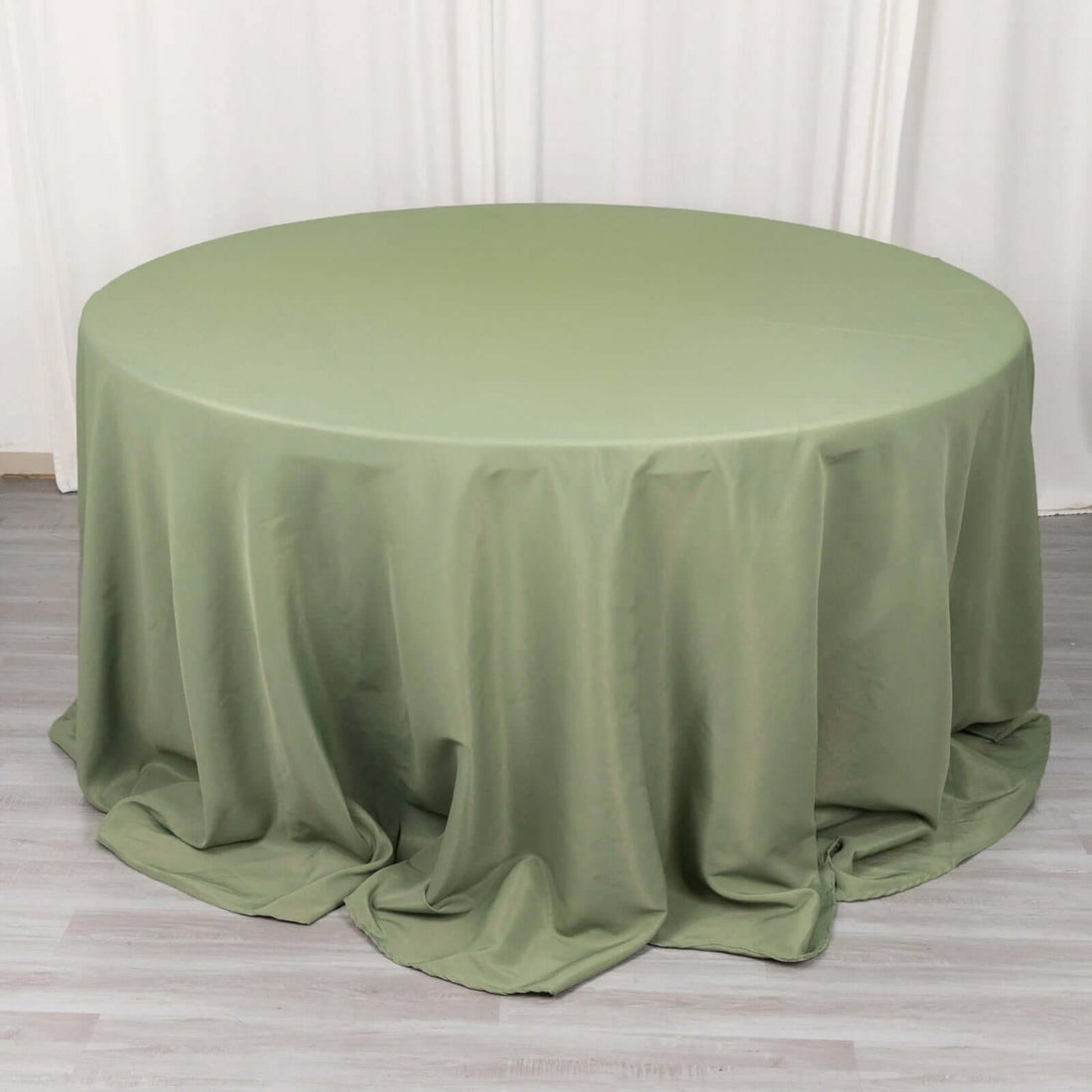 Round olive green tablecloth draping elegantly over a circular table.