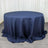 Navy round tablecloth with elegant draping on a wooden floor.
