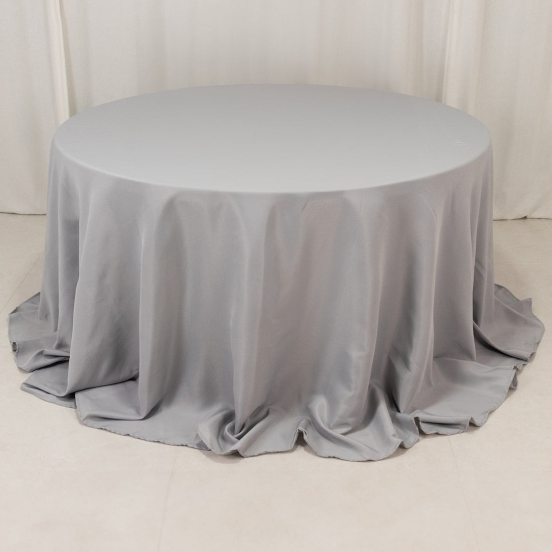 Round gray tablecloth draped elegantly on a round table.