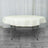 Round folding table with a cream-colored tablecloth.