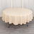 Round beige tablecloth draped over a table in a studio setting.