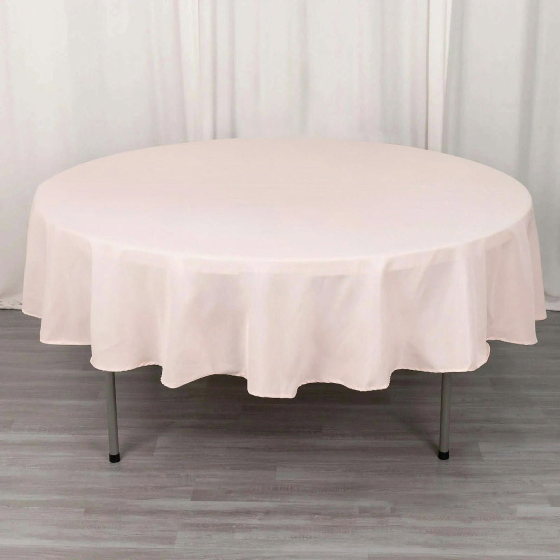 Round table covered with a soft pink tablecloth