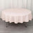 Round table covered with a soft pink tablecloth