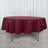 Round maroon tablecloth draped over a table in a studio setting.