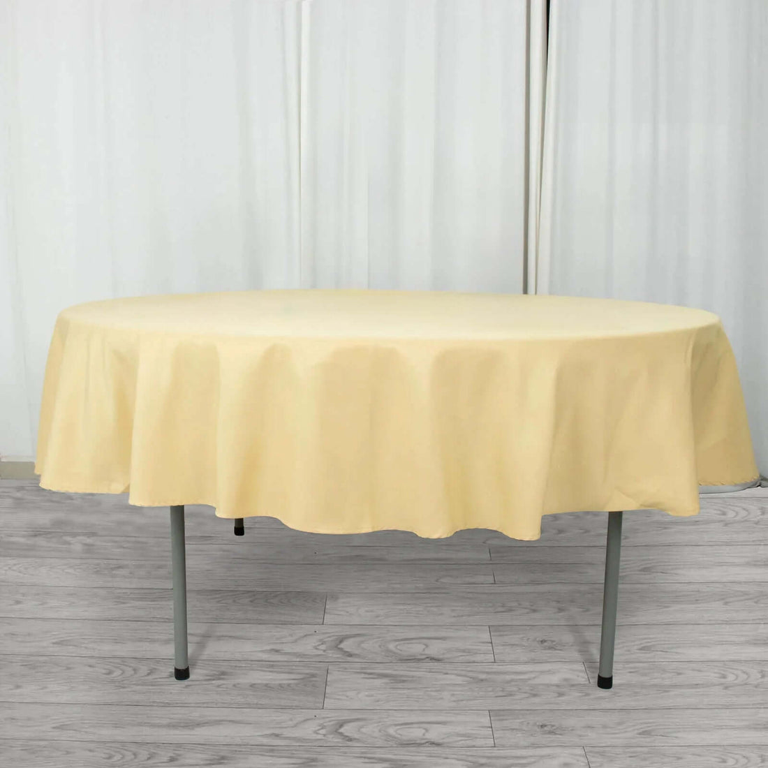 Round yellow tablecloth on a table in a staged setting.