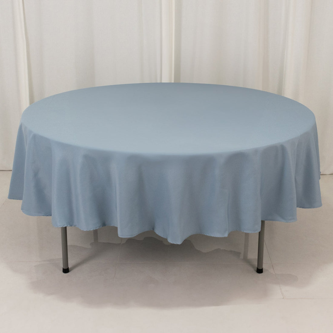 Round blue tablecloth on a table against a plain background.
