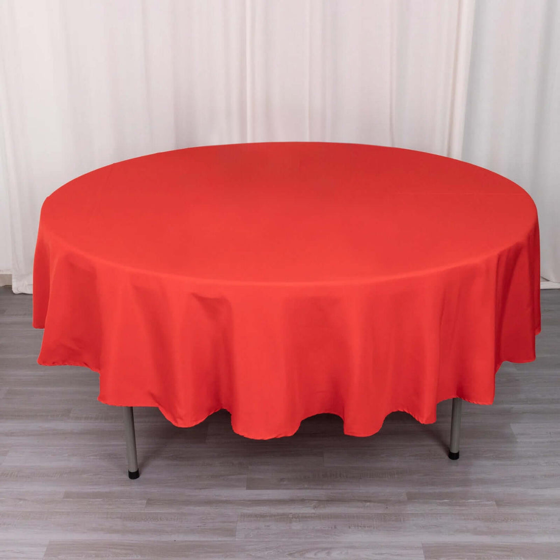 Round red tablecloth on a table with a neutral background.