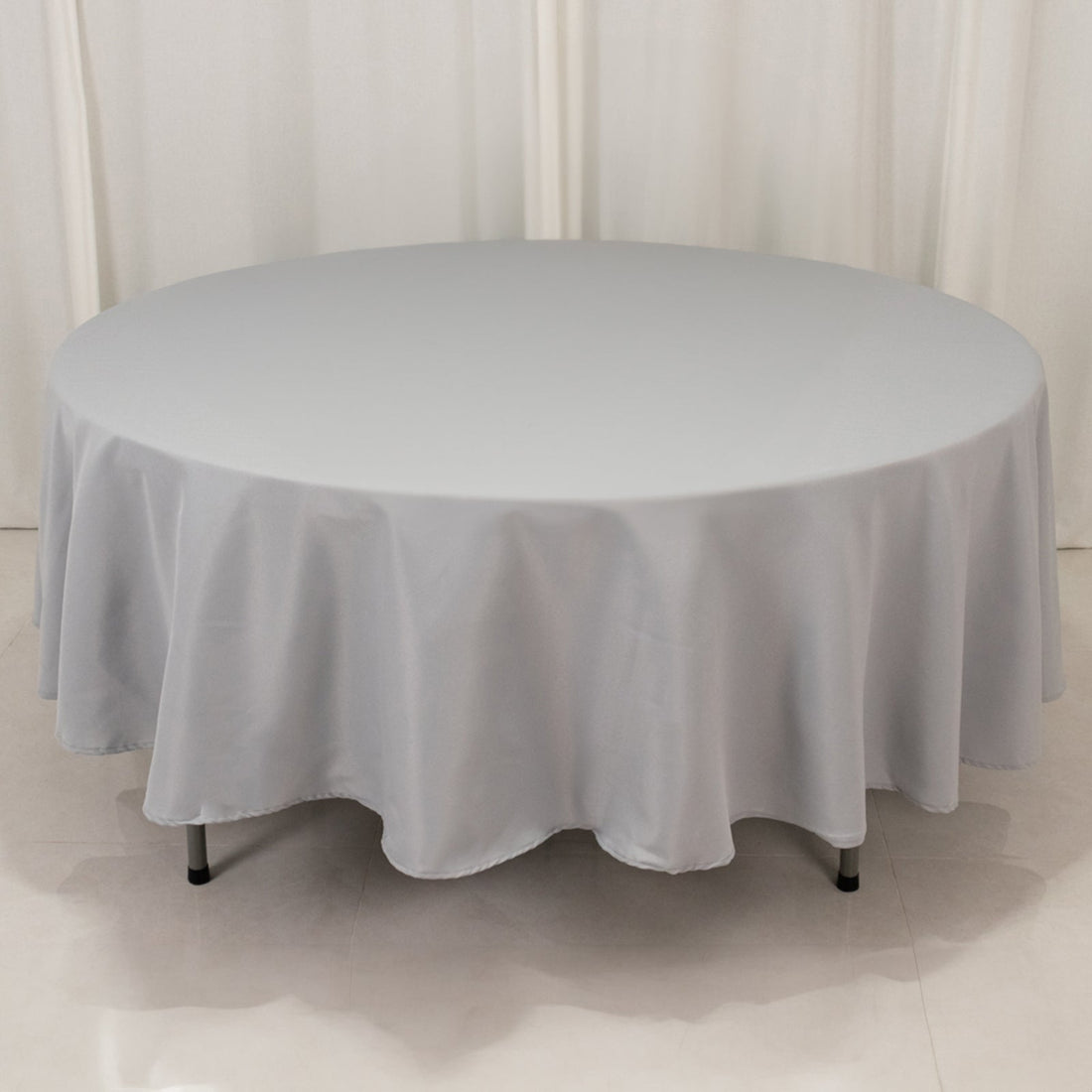 Round gray tablecloth with draped edges on a plain surface.