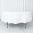 White tablecloth draped over an oval table in a studio setting.