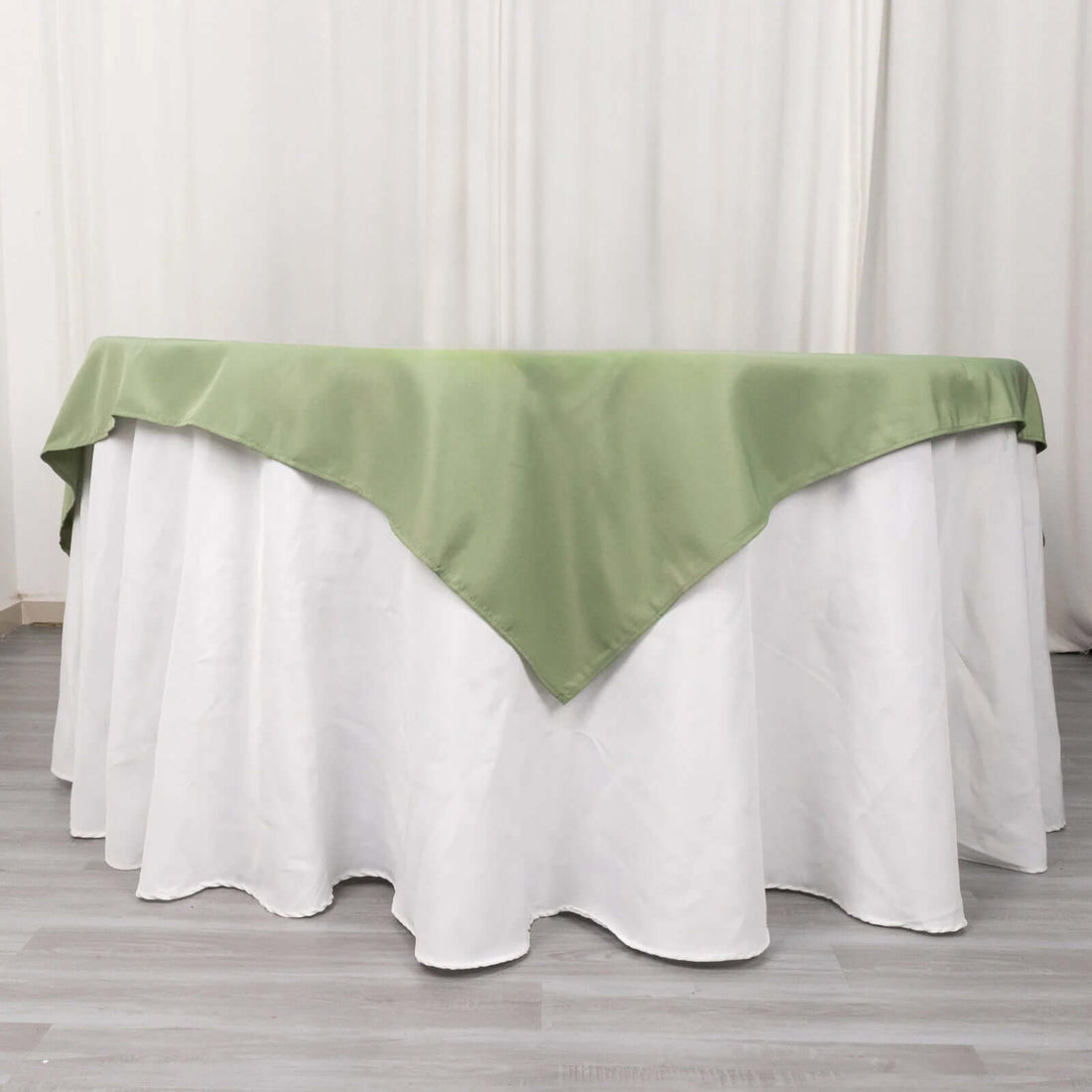 Green tablecloth with white underlay in a studio setting.