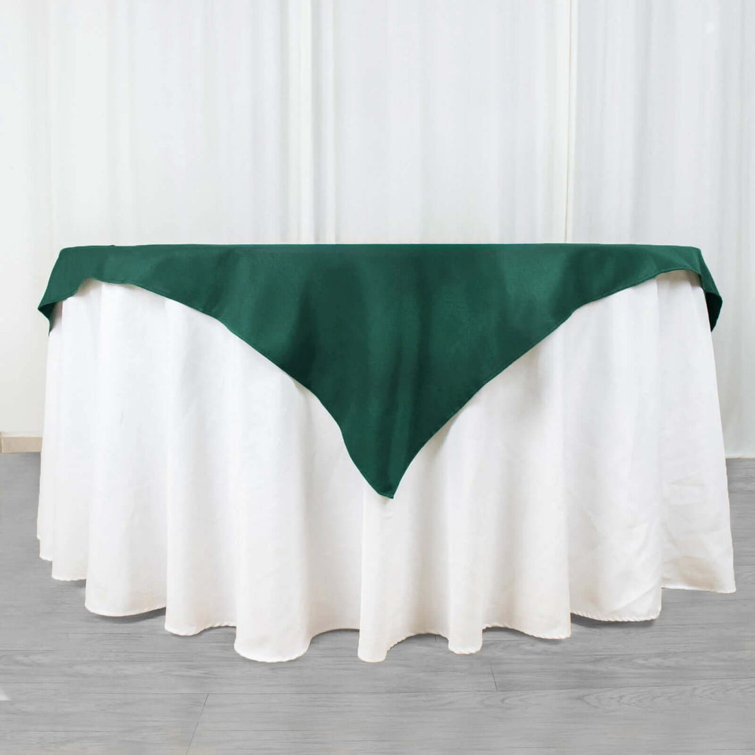 Green tablecloth draped over a white table for elegant dining.