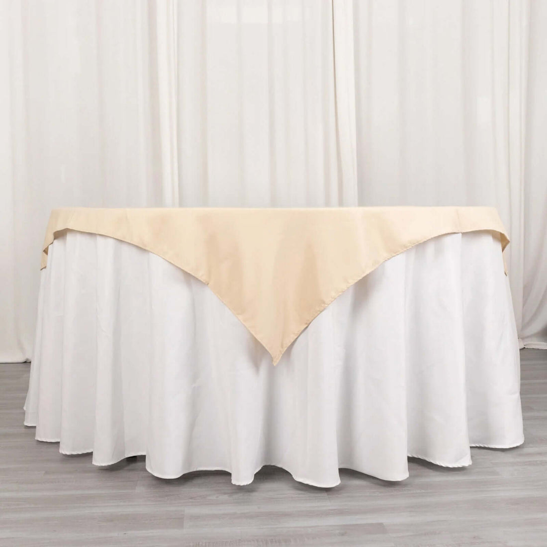 Beige table cover with white skirt on a round table