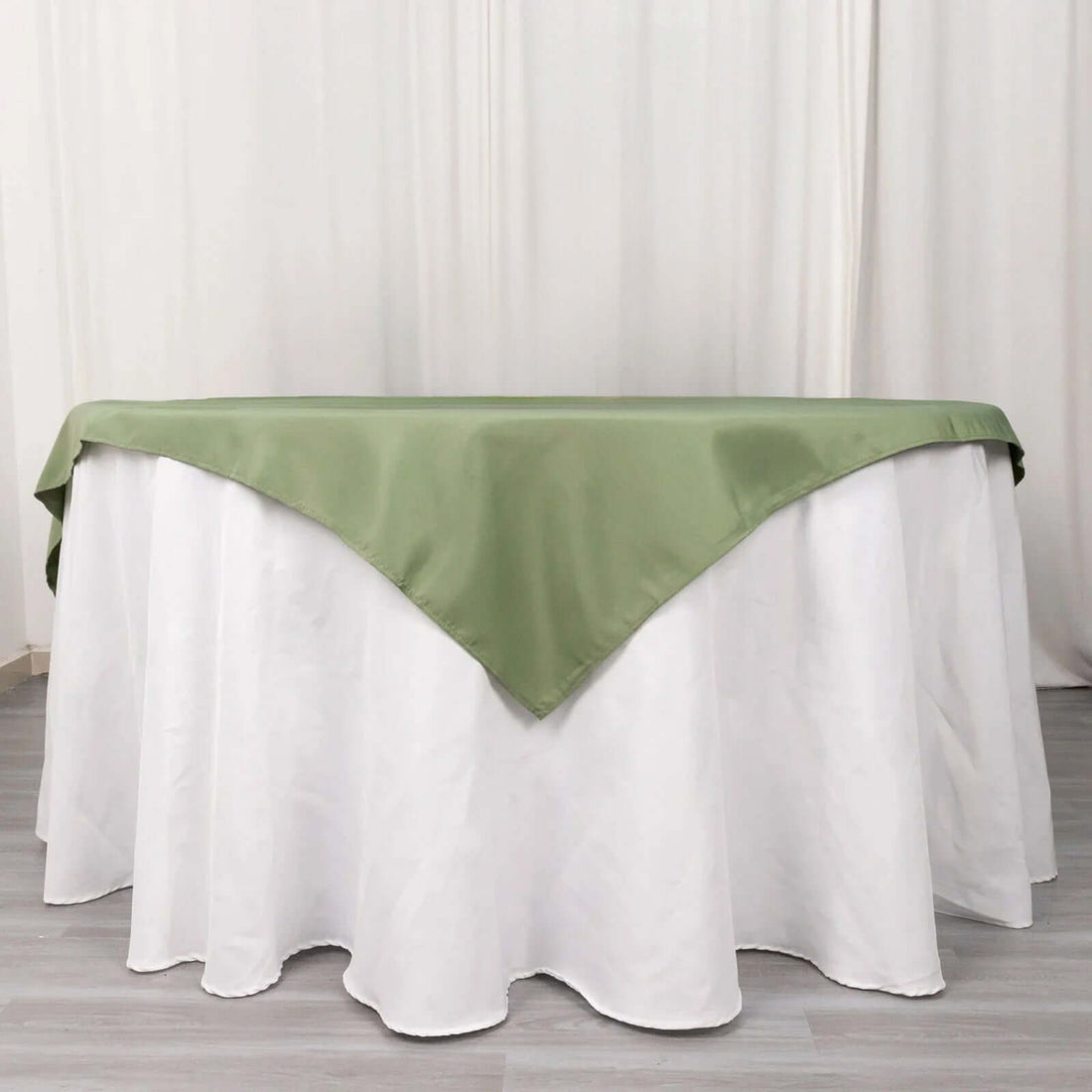 Green satin tablecloth draped over a white table.