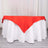 Red tablecloth draped over a white table for elegant dining decor.