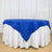 Blue tablecloth with white underlayer, elegantly draped on a round table.