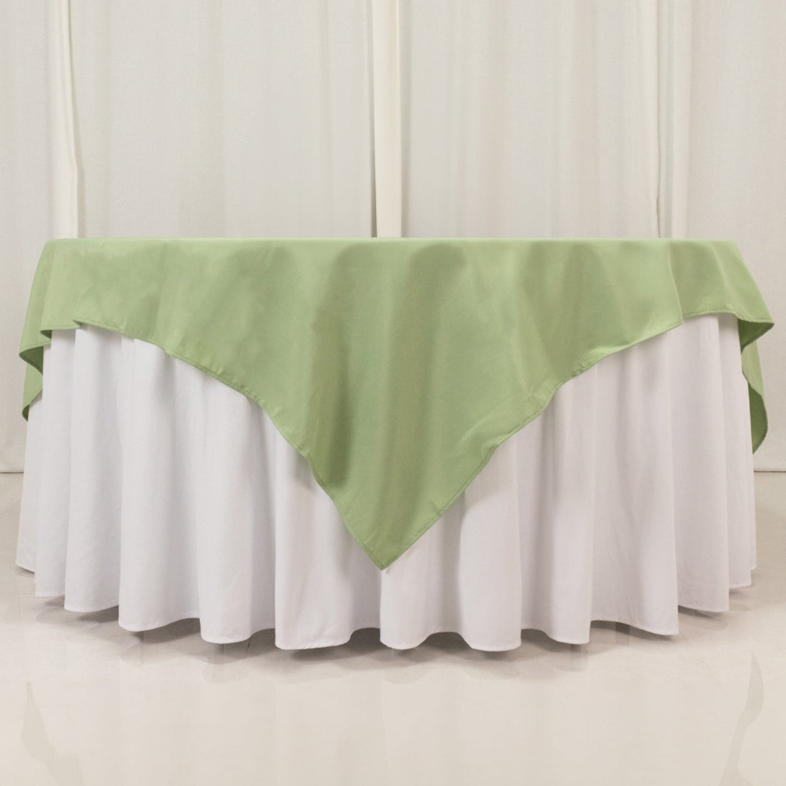 Green tablecloth draped over a white table for elegant dining decor.
