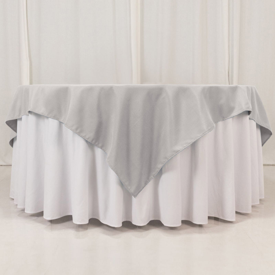 Gray tablecloth layered over a white table for elegant event styling.
