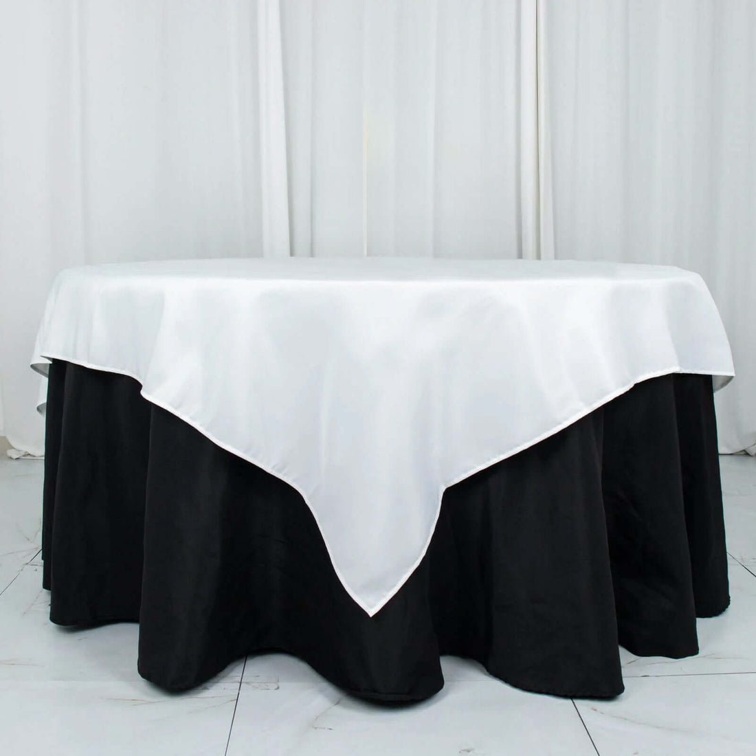 Black and white tablecloth with elegant draping on a round table