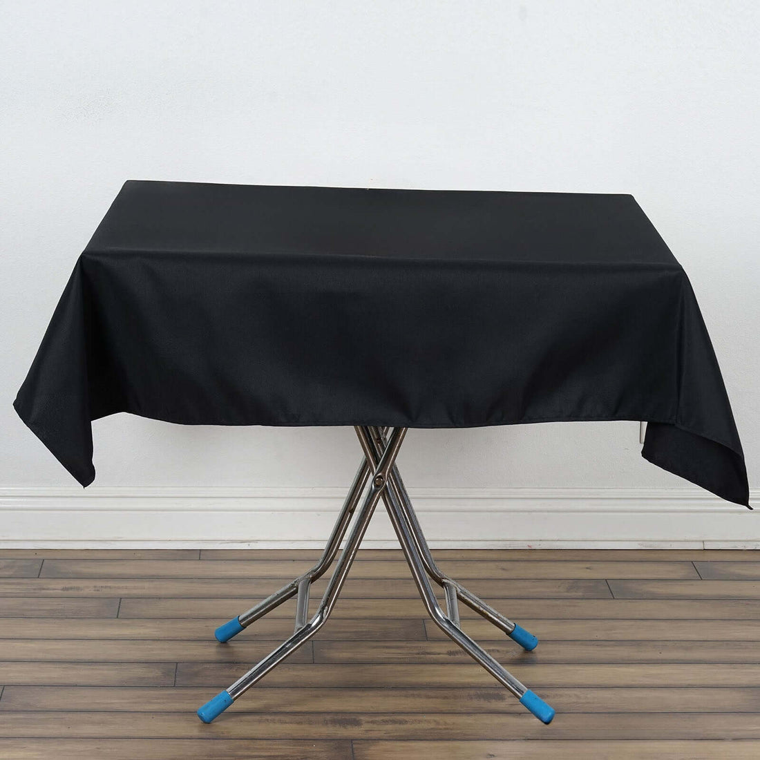 Black tablecloth draped over a folding table with metallic legs.