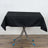 Black tablecloth draped over a folding table with metallic legs.