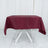 Burgundy tablecloth draped over a white folding table