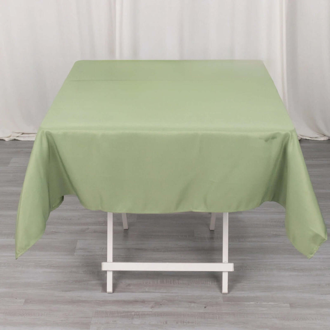 Green tablecloth draped over a table in a studio setting