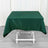 Green tablecloth draped over a white folding table in a studio setting.