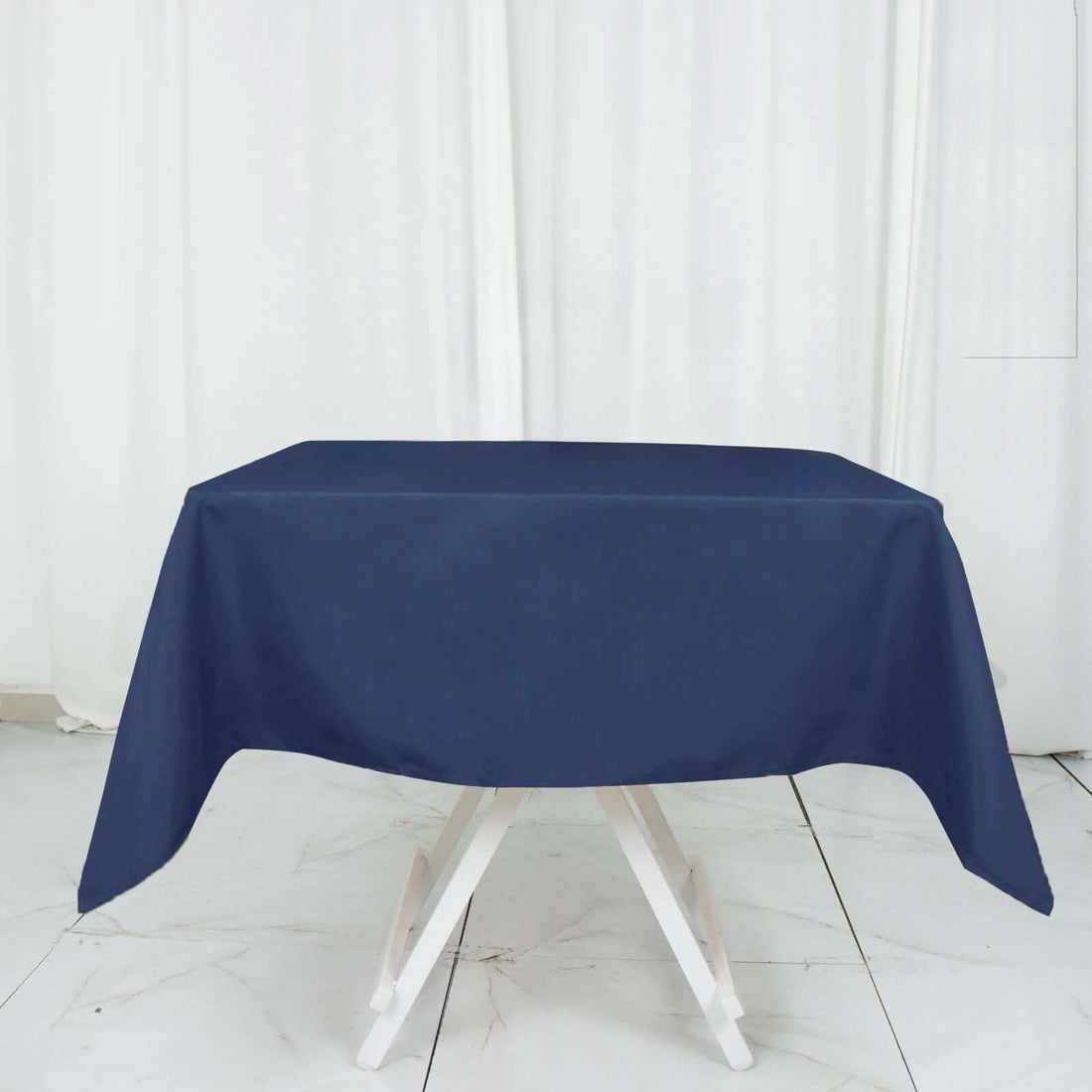 Navy blue tablecloth draped over a white folding table
