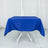 Blue tablecloth draped over a white table against a plain backdrop