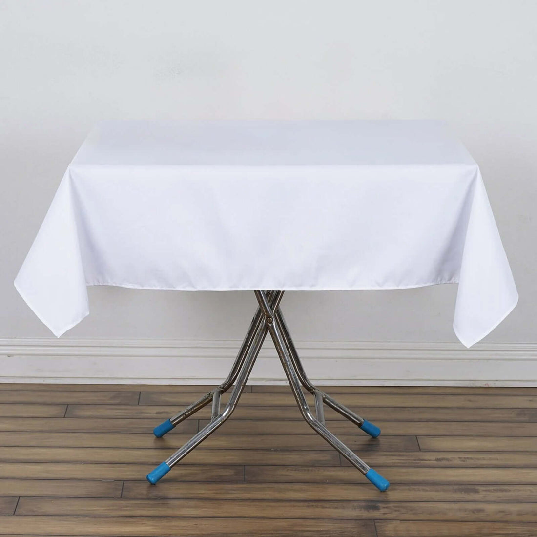 White tablecloth draped over a folding table with metal legs.