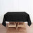 Black tablecloth draped over a wooden table in a styled interior setting.