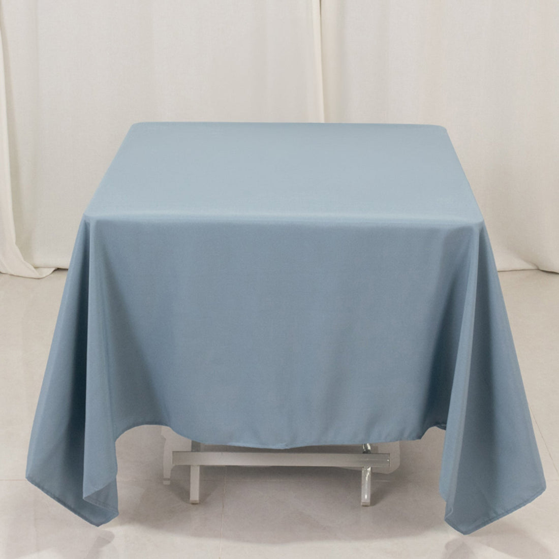 Blue tablecloth draping over a square table