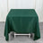 Green tablecloth draped over a table with a plain backdrop.