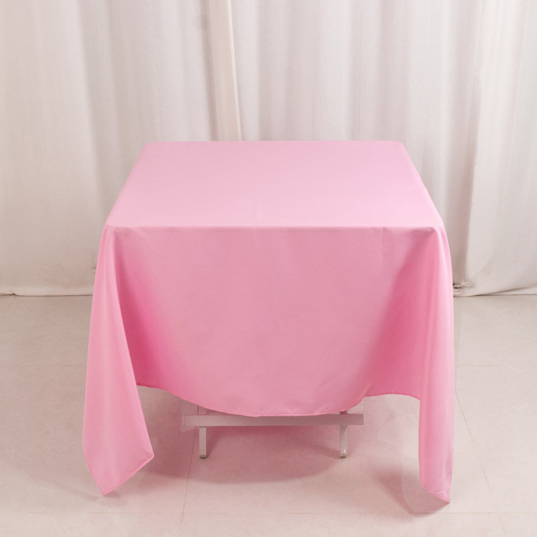 Pink tablecloth draped over a table in a studio setting.